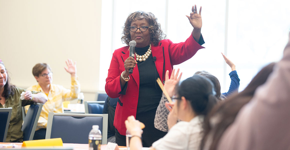Photograph of an African American instructor, Dr. Denise Williams, leading a group of students in a day lecture class or workshop.