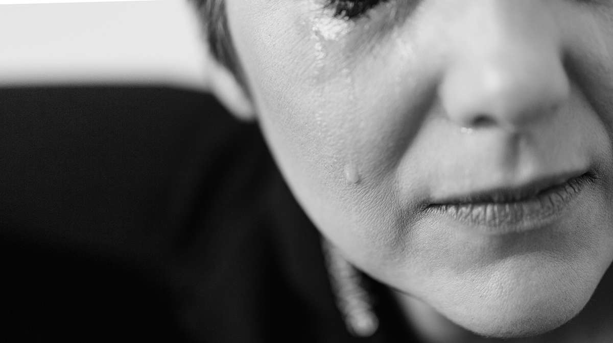 closeup of part of a face with a single tear running down a cheek.