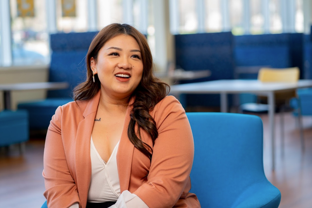 Woman smiling and seated on blue chair