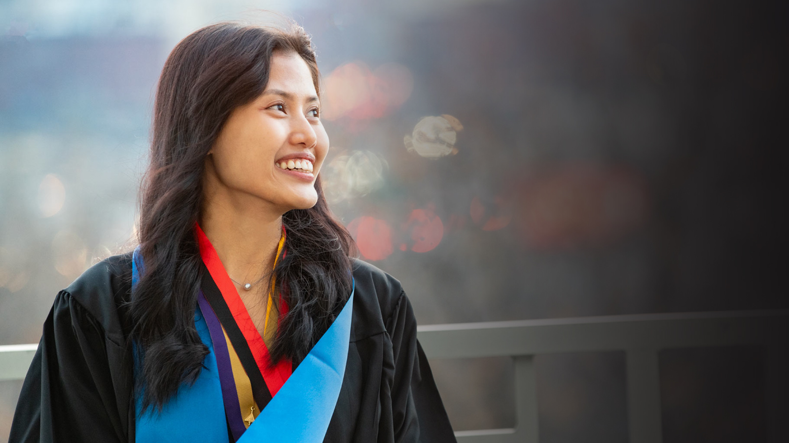 Student smiling in commencement attire