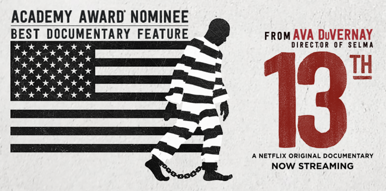 Picture of a clack and white American flag, with an image of a person in historical striped prisoner clothing with its stripes lining up with the flag's, giving the impression that the prisoner is stepping out of the flag.
