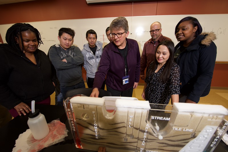 faculty and students observing a model in environmental science classroom