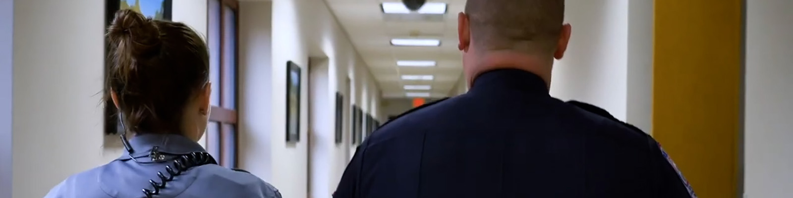 Woman and man wearing uniforms walking down hallway