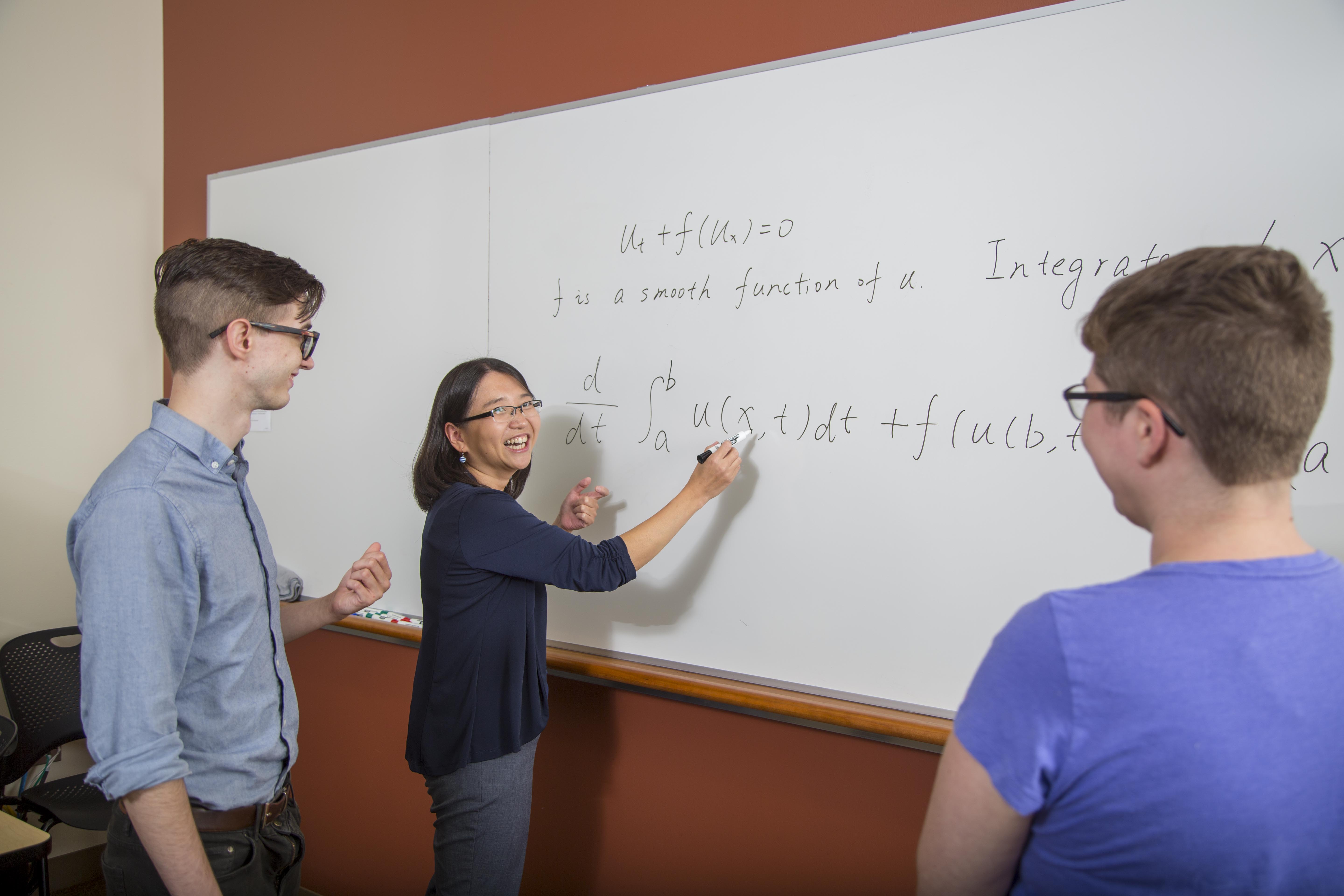 students and faculty at whiteboard