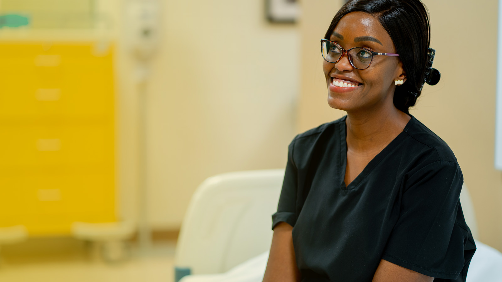 Nursing student smiling in black scrubs