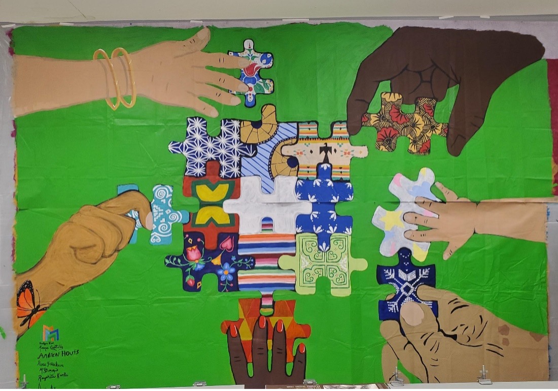 a mural depicting many different hands placing various puzzle pieces together, each representing a different community