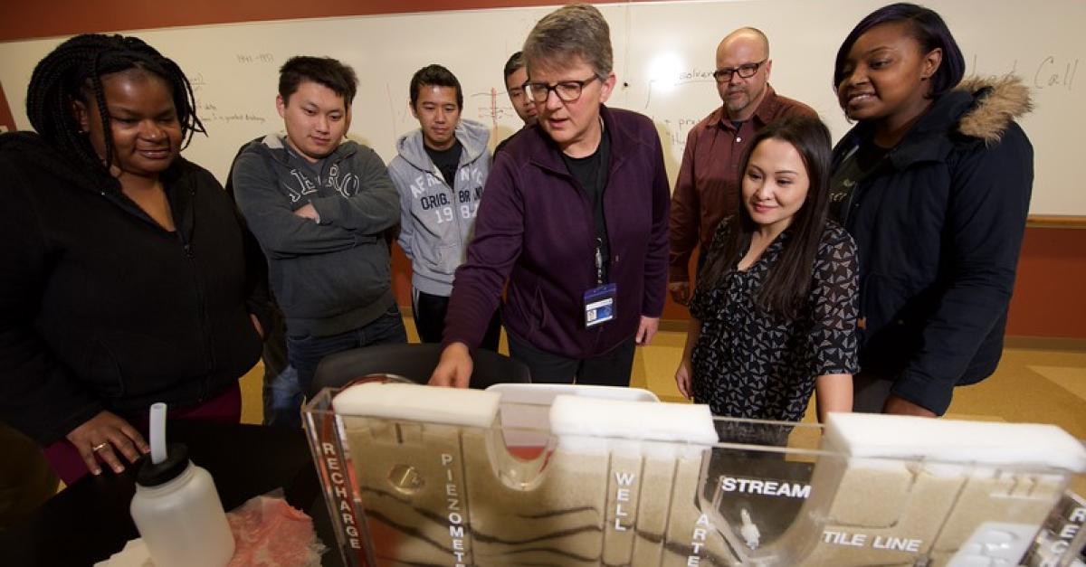 faculty and students observing a model in environmental science classroom
