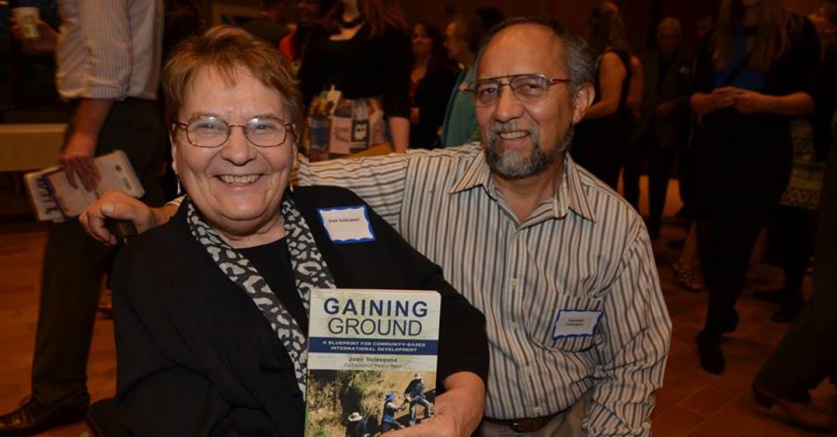 Joan and Segundo holding the book "Gaining Ground"