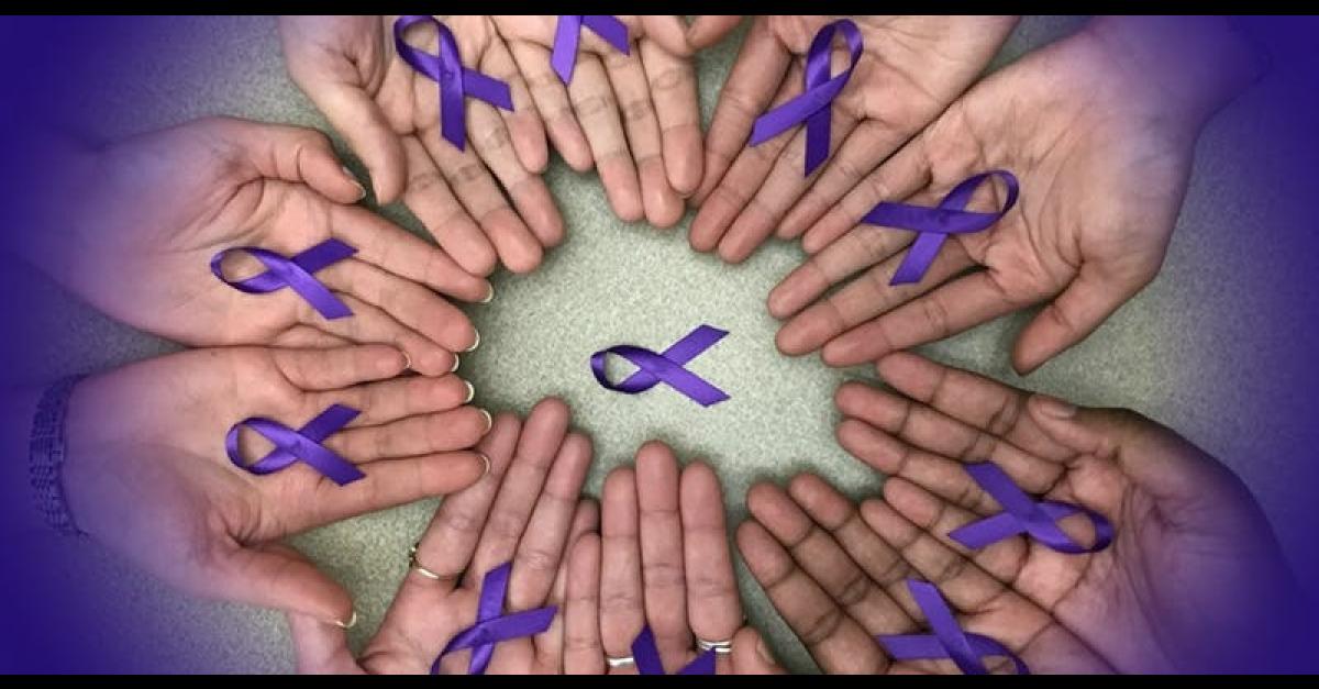 Circle of hands holding purple ribbons