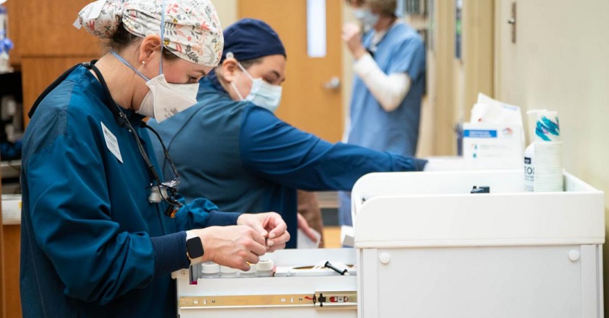 Students in protective gear work in a lab