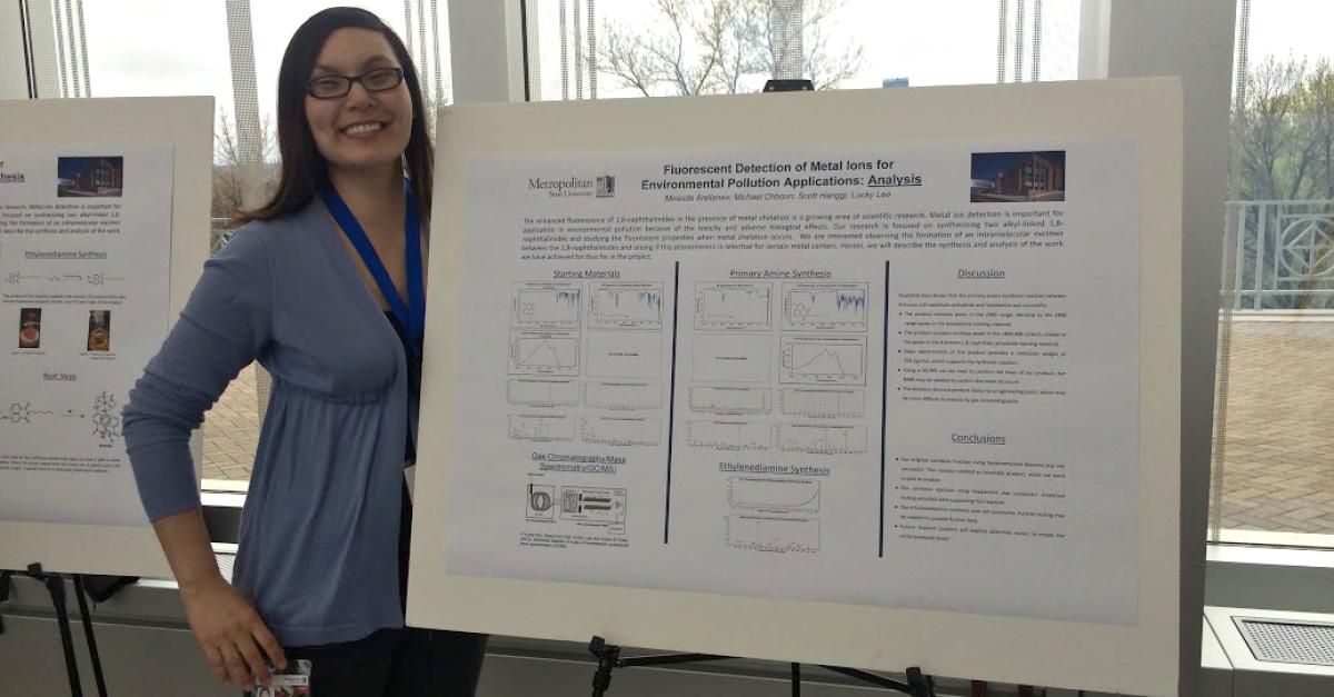 Woman displays her work at the Student Poster Conference
