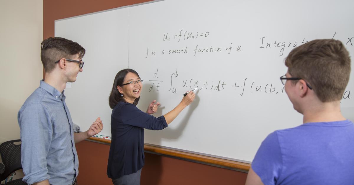 students and faculty at whiteboard