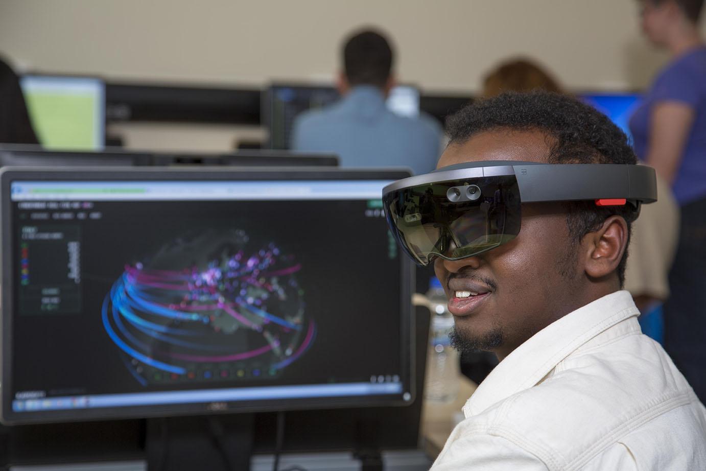 Student using wearable in front of screen showing map of traffic