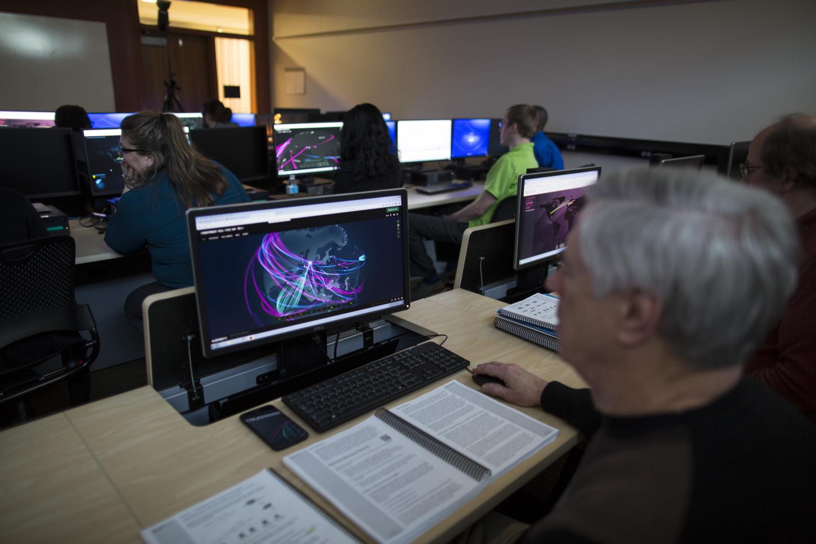 Students in computer lab looking at cyber security threats.