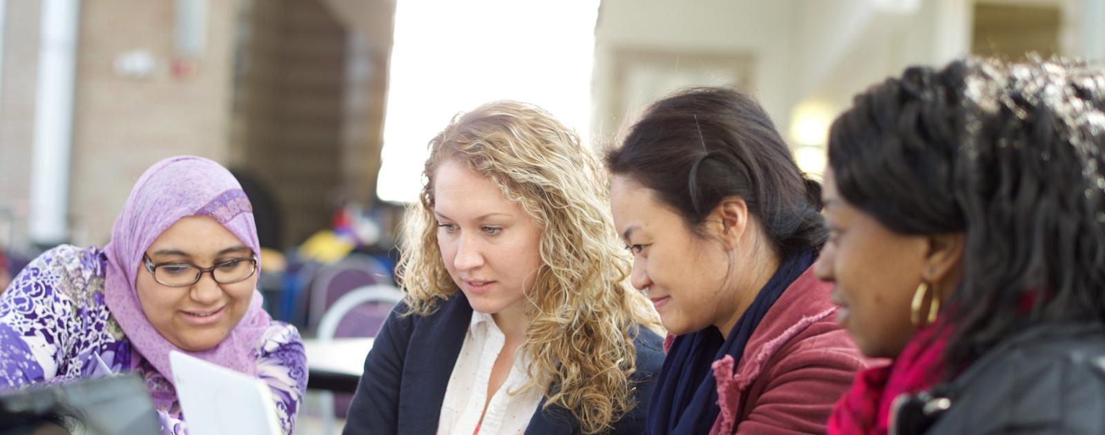 Four students sit around a computer