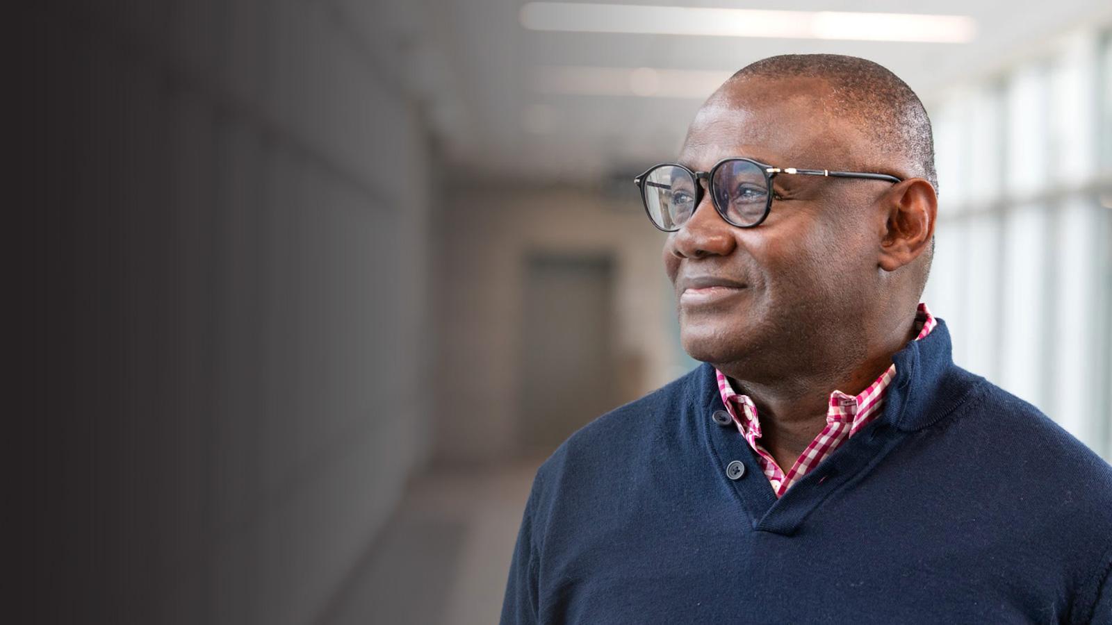 a person poses for a picture in the Metro State skyway to the Library