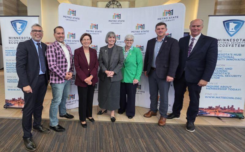 A group of faculty, lawmakers, and others pose for a portrait 