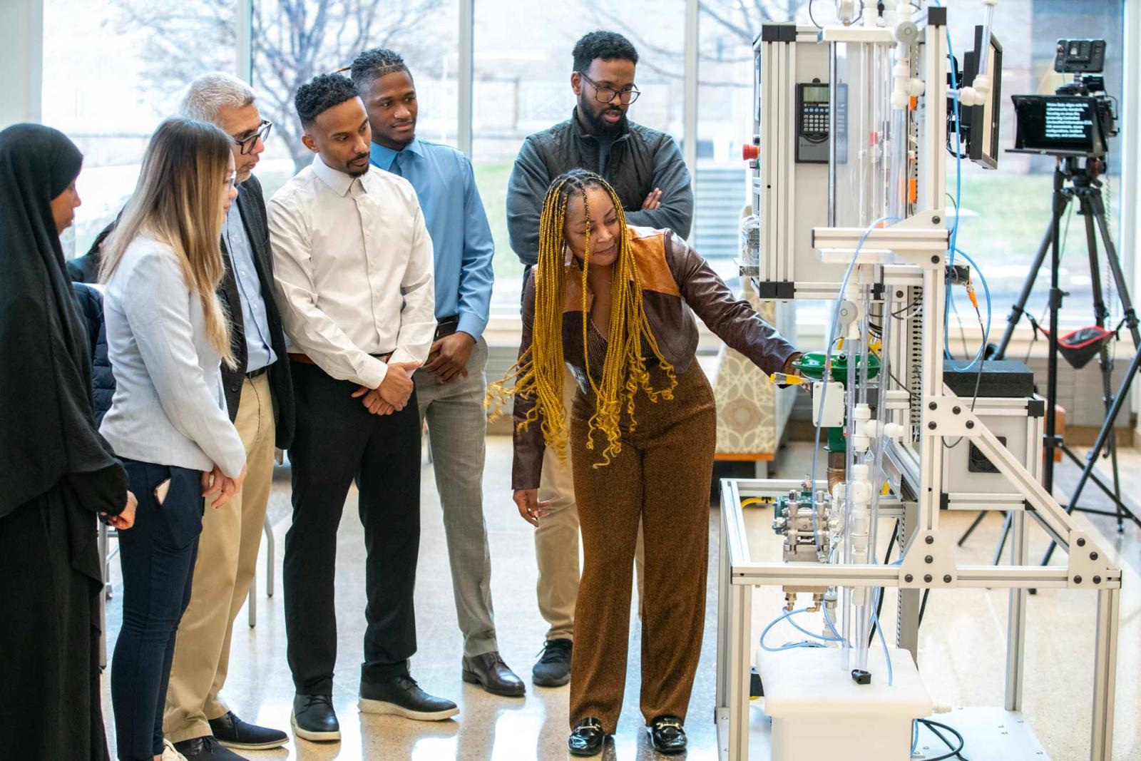 A person demonstrated a piece of lab equipment to a small group