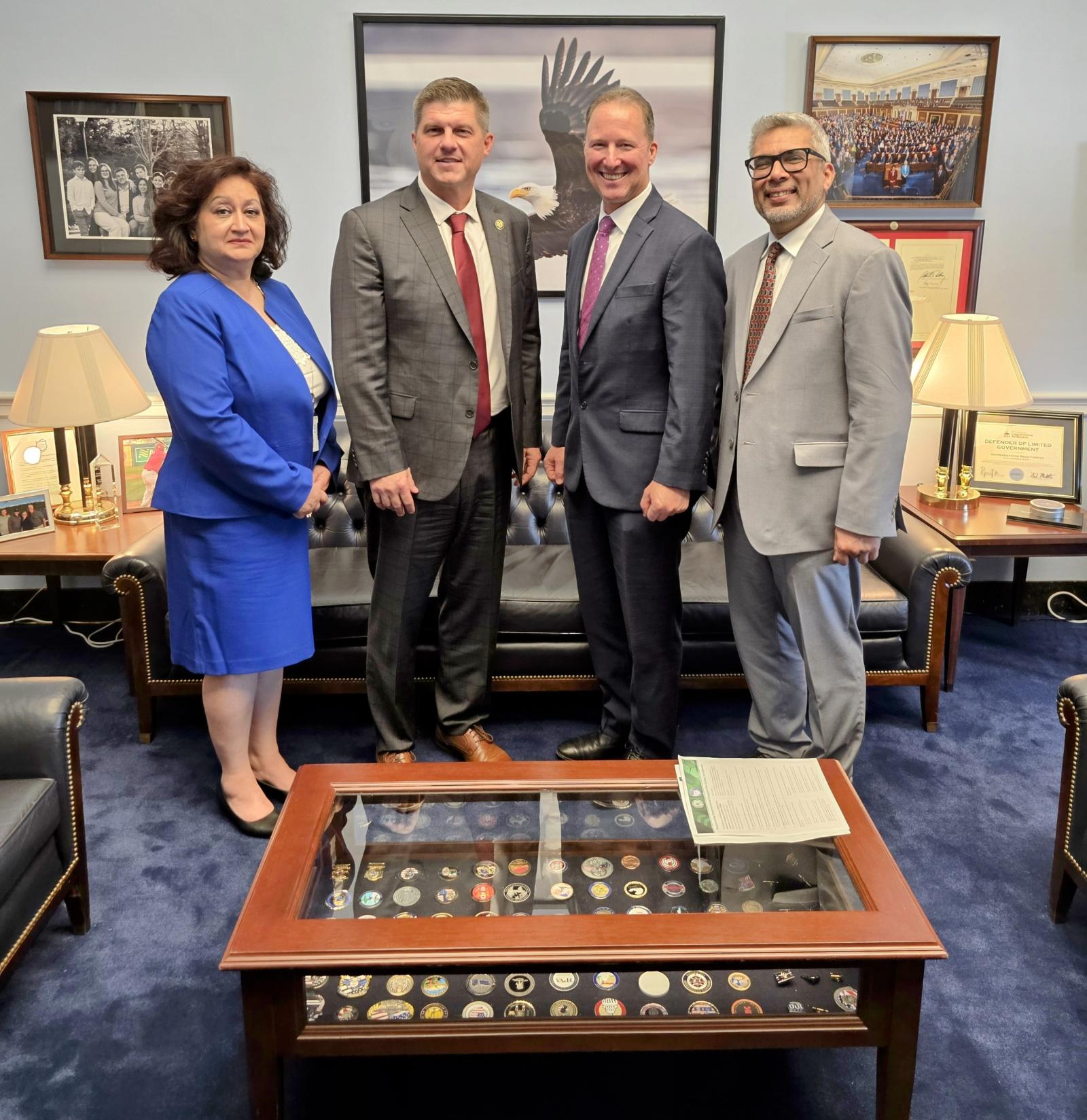 Dr. Diba Hadi, Congressman Brad Finsted, Mark Gorak, and Professor Faisal Kaleem pose for a picture in an office