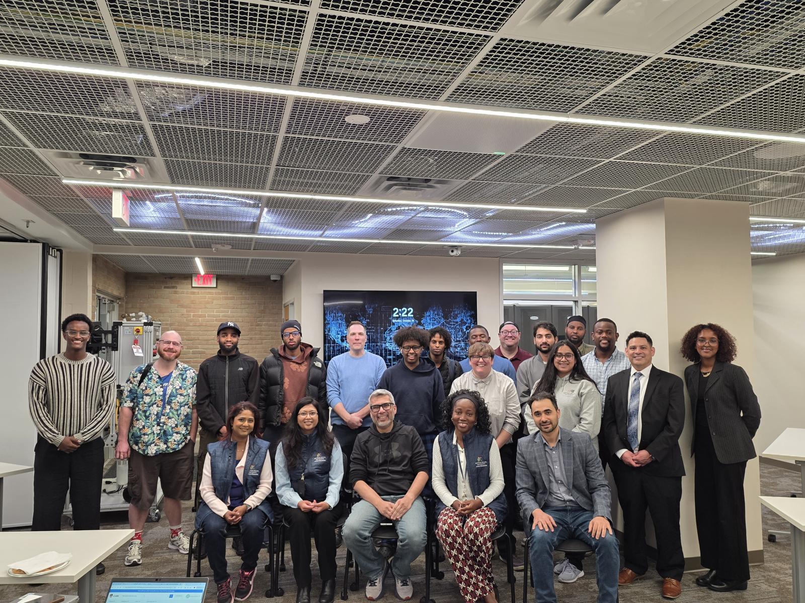 a group of people posing for a photo in a computer lab