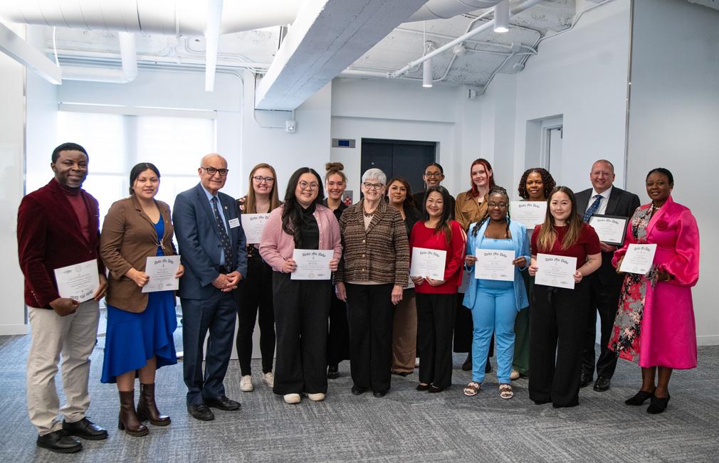 A group of people pose in the Management Education Center for Delta Mu Delta induction ceremony, March 28, 2026