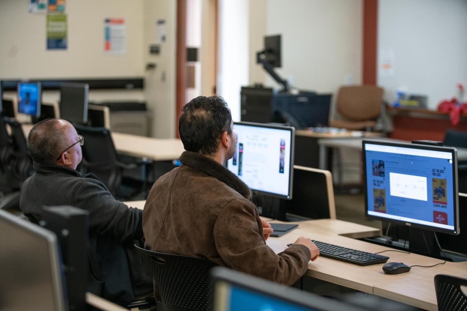 Students at computers look toward an instructor (not pictured)