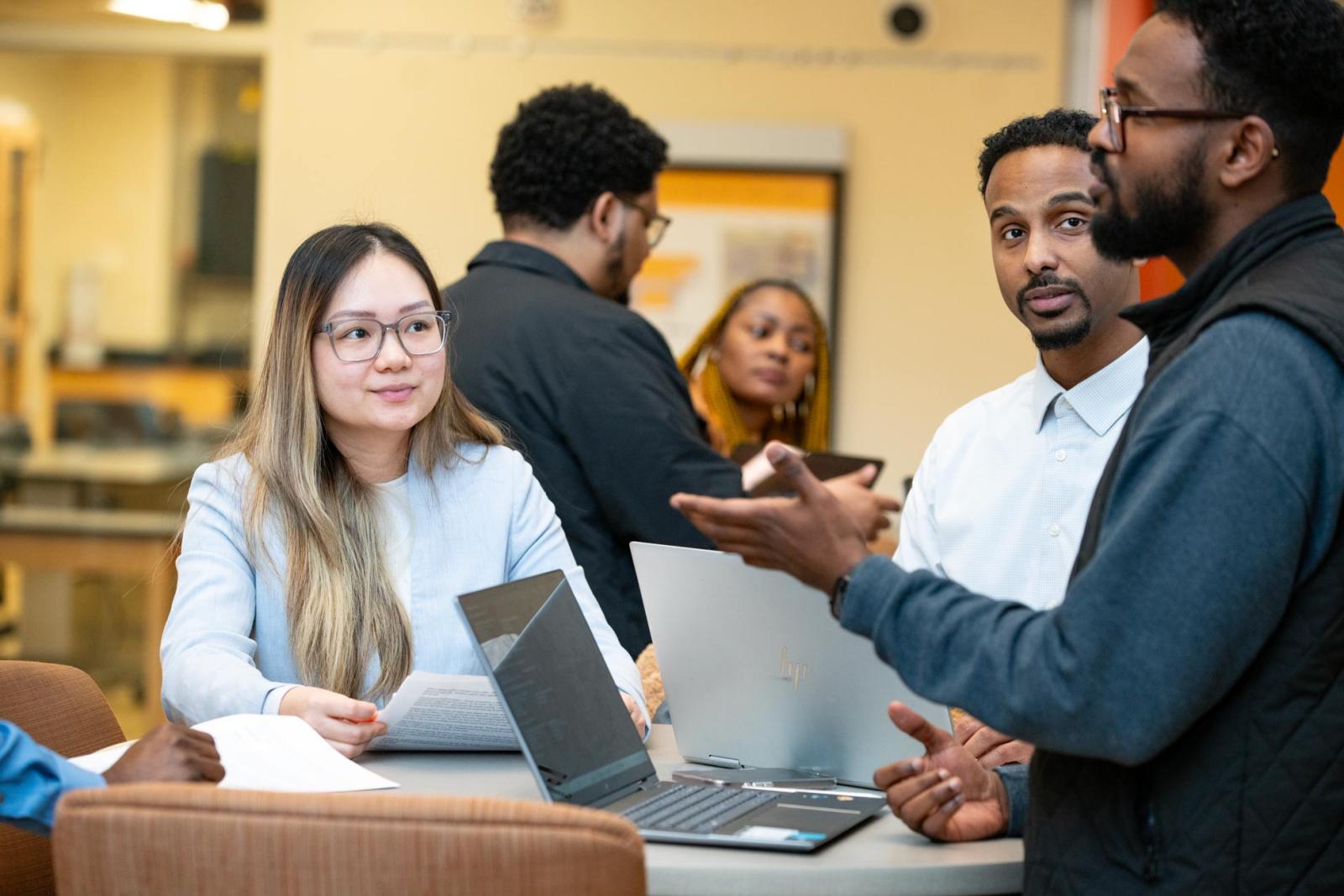 Students work through a problem with a laptop