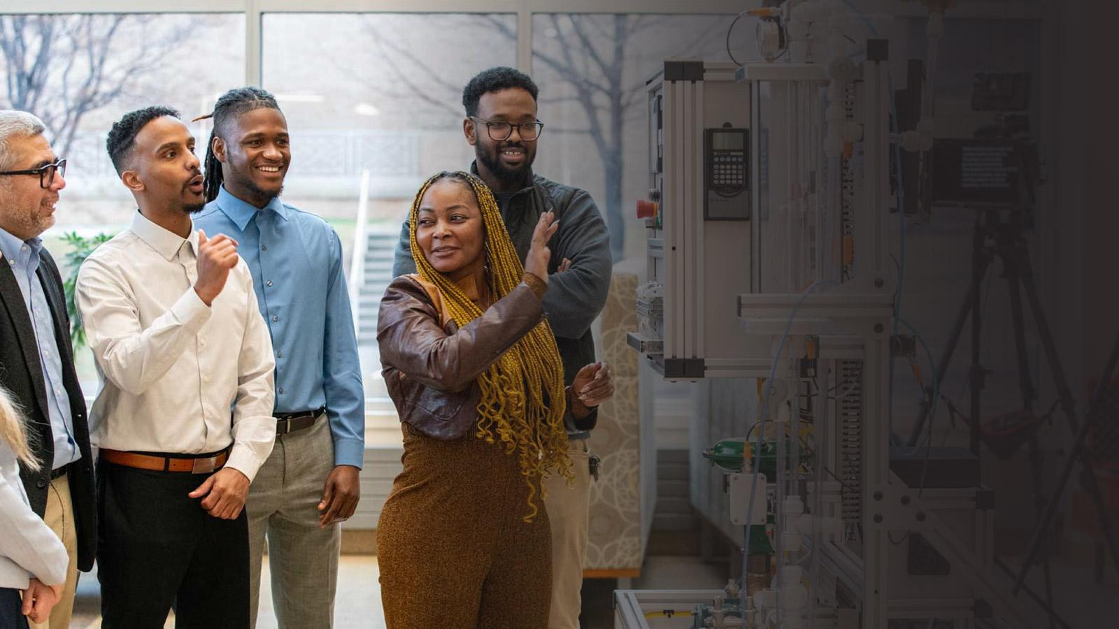 A group of people look at technology in a lab