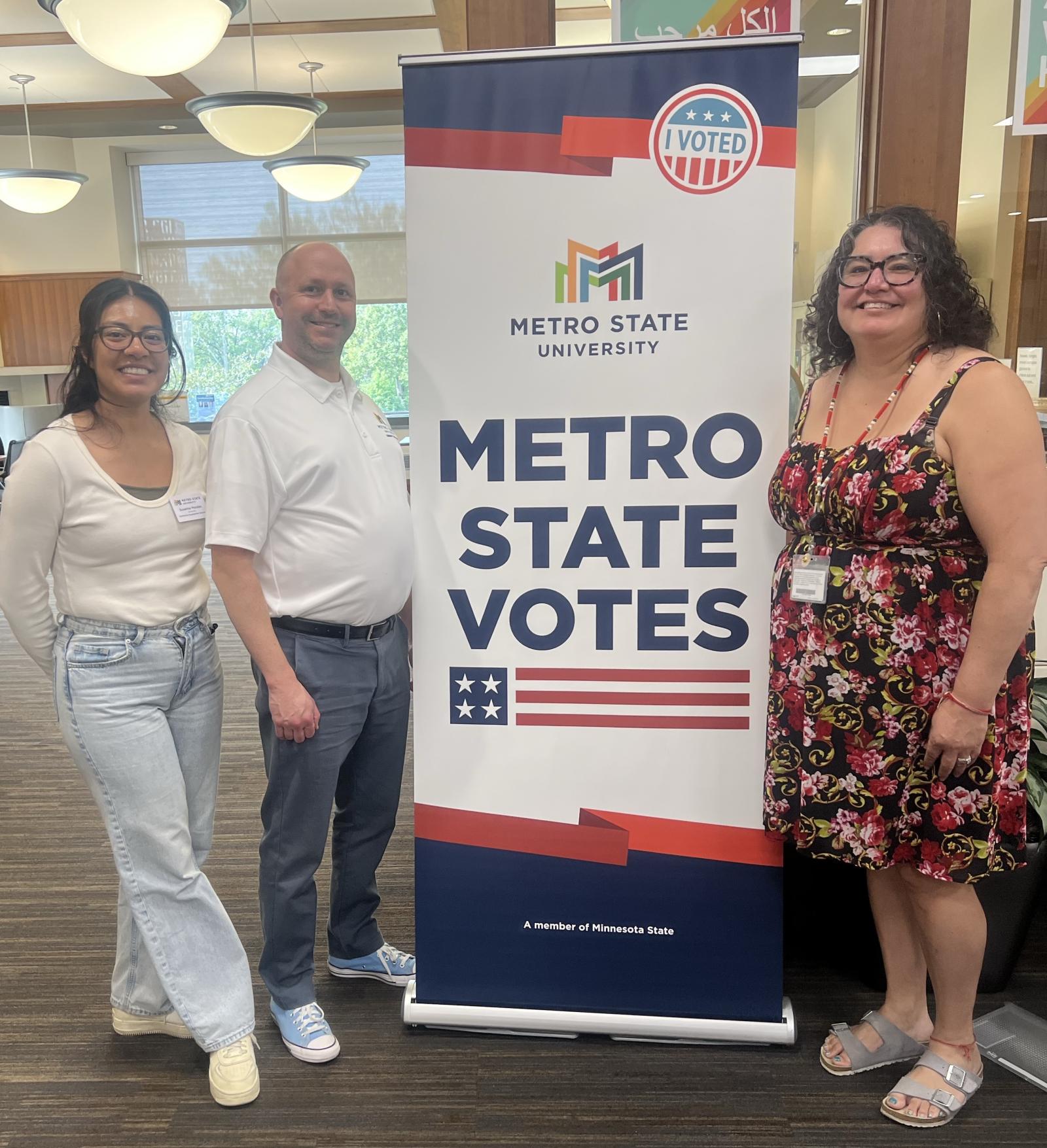 A group of people stand next to a Metro State Votes banner