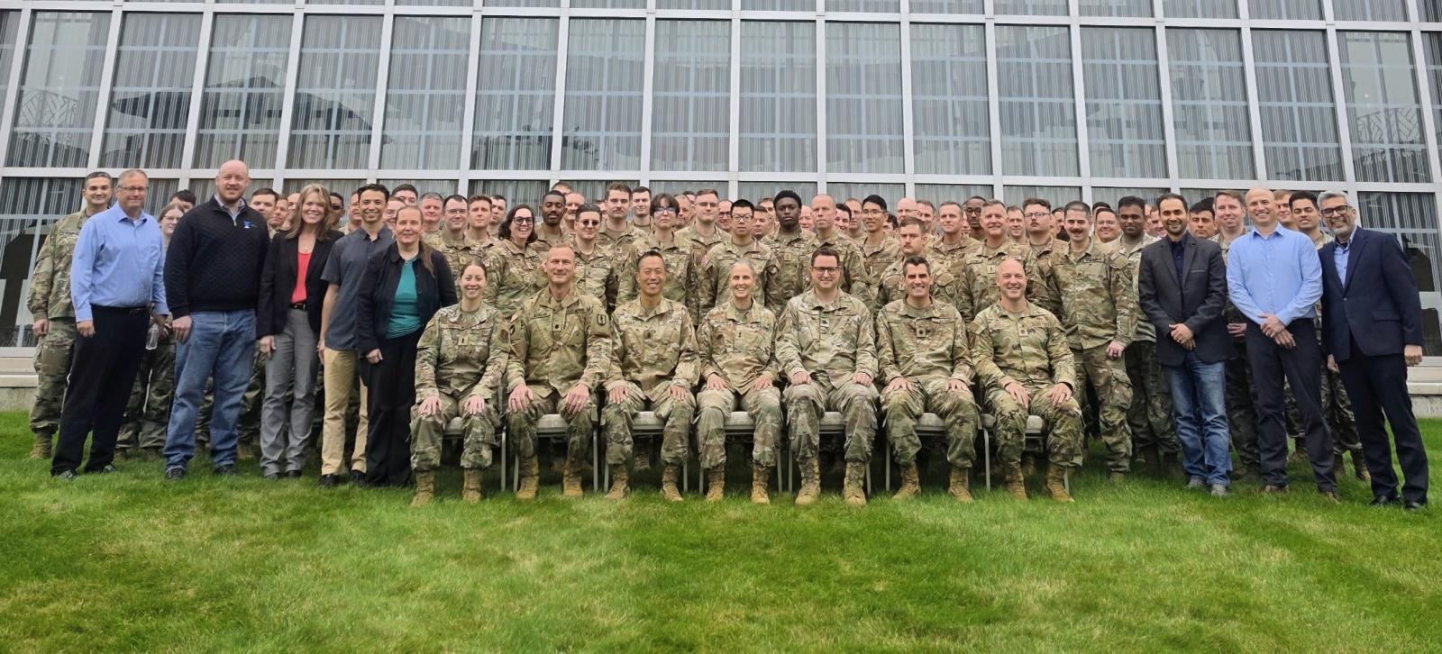 A large group of people pose for a group photo in front of New Main
