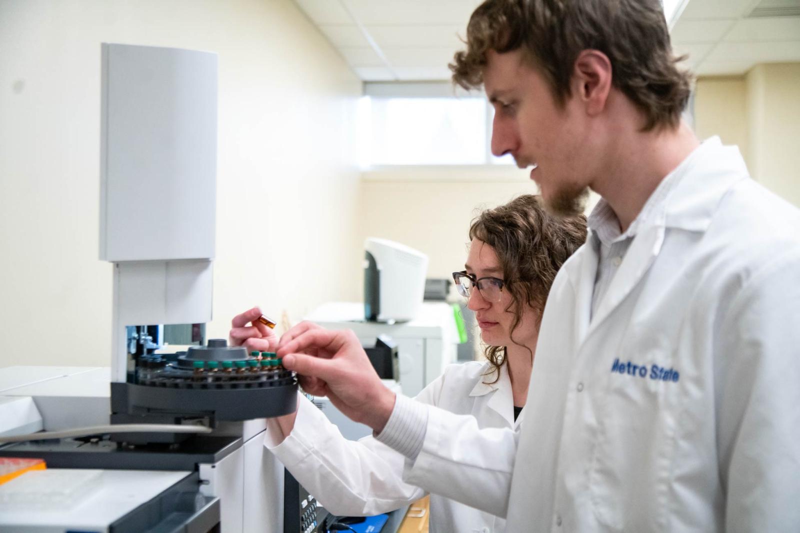 Two students in a lab inspect samples