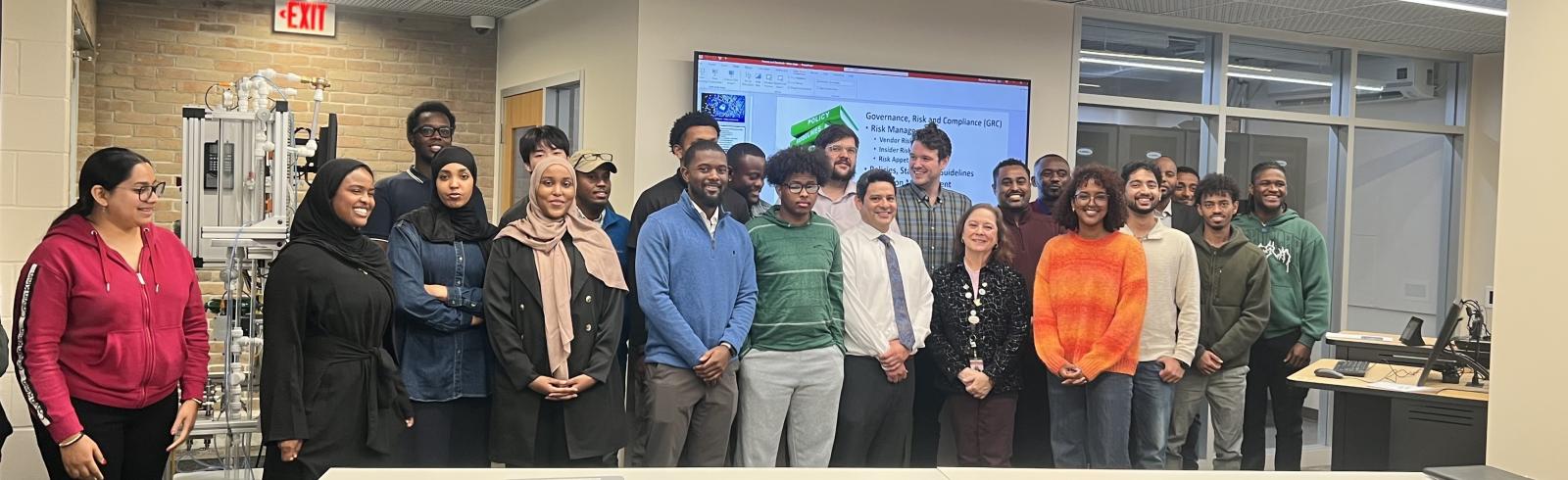 A group of people pose for a photo in a classroom