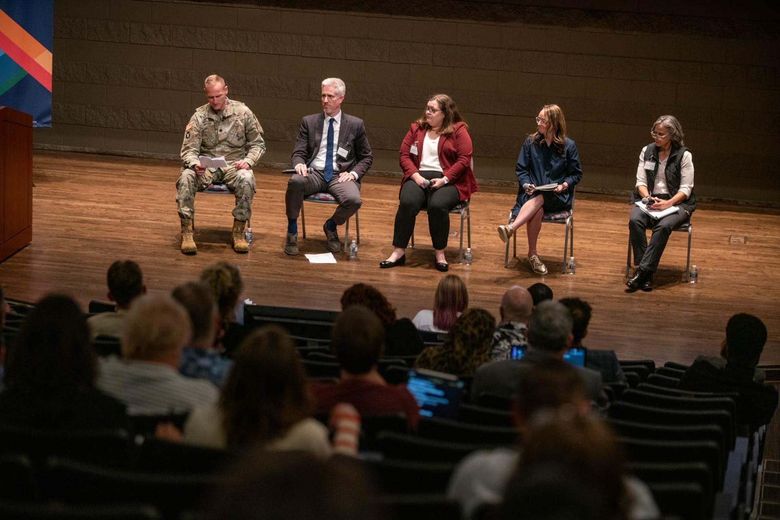 A panel sitting on the stage in the Founders Hall Auditorium
