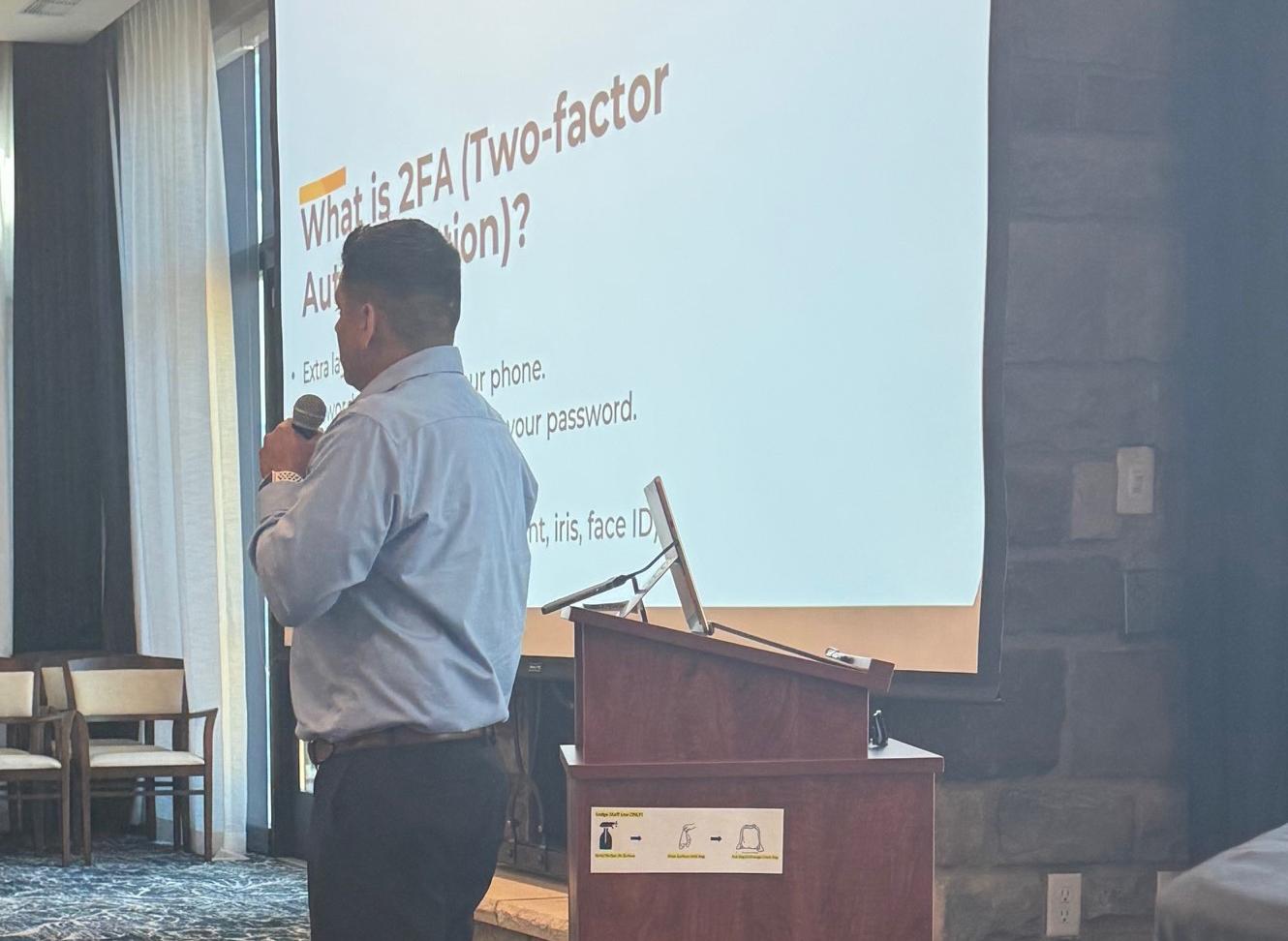 a speaker presenting in front of a large screen