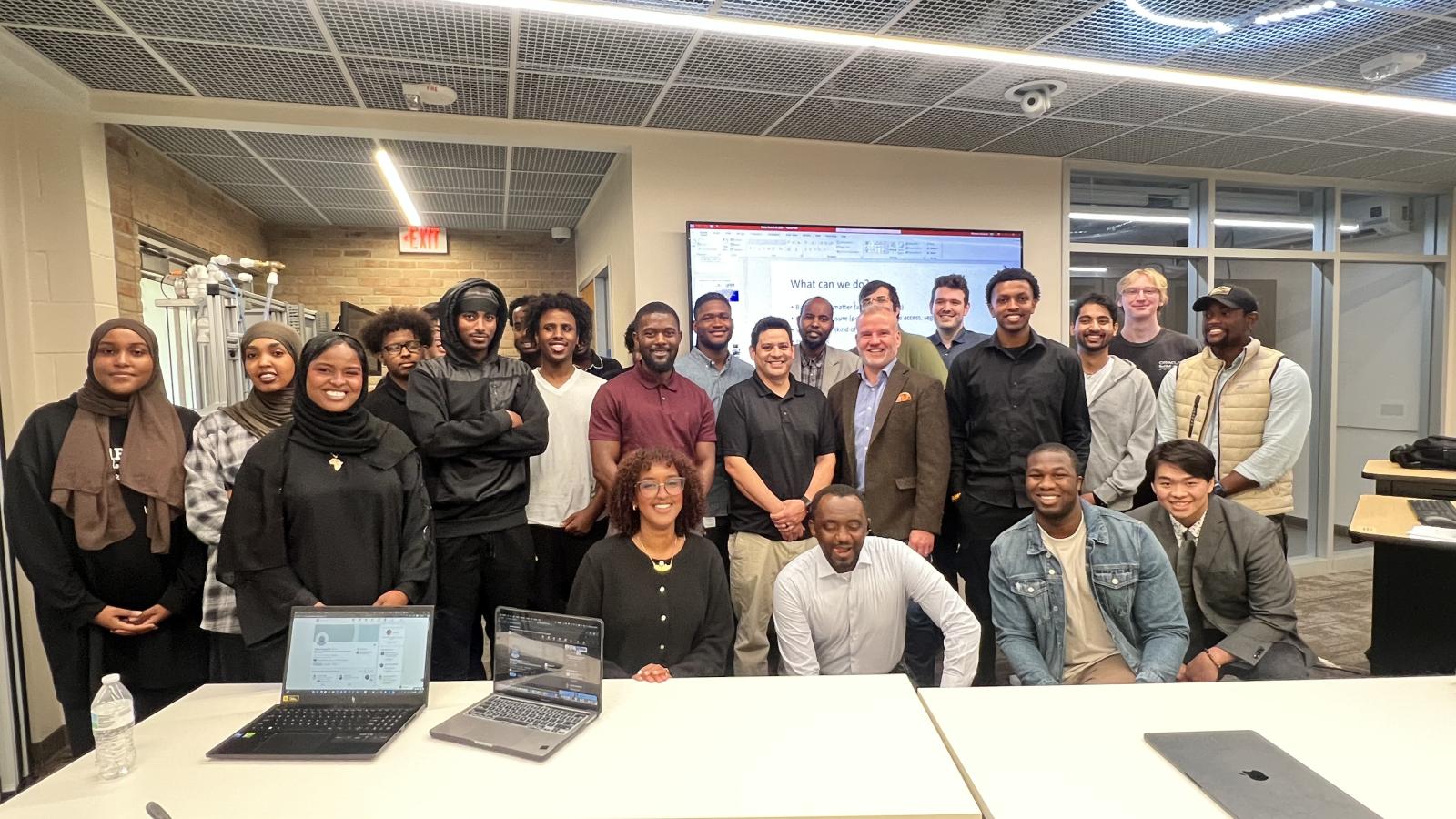A group of people pose for a picture in a classroom