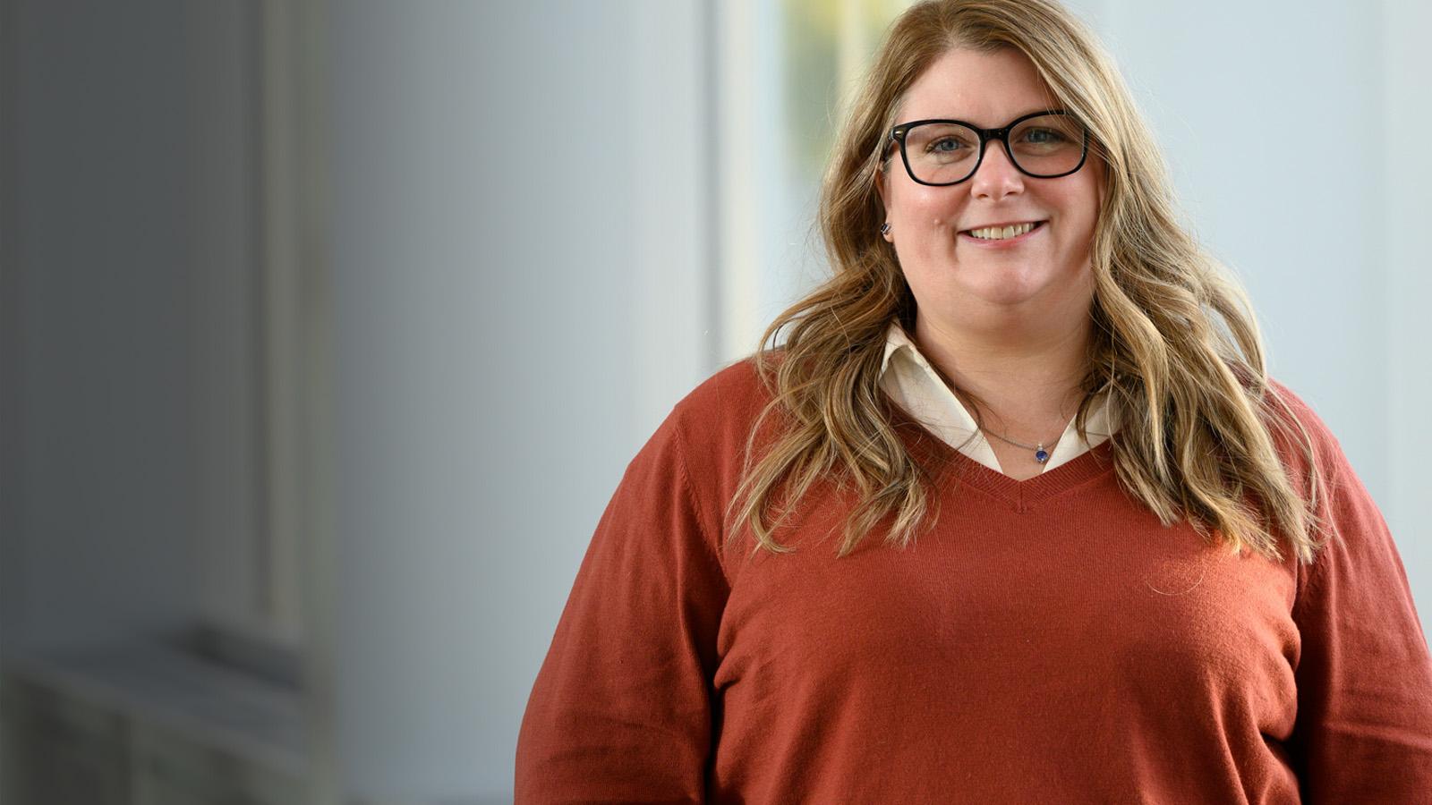Student smiling in orange sweater