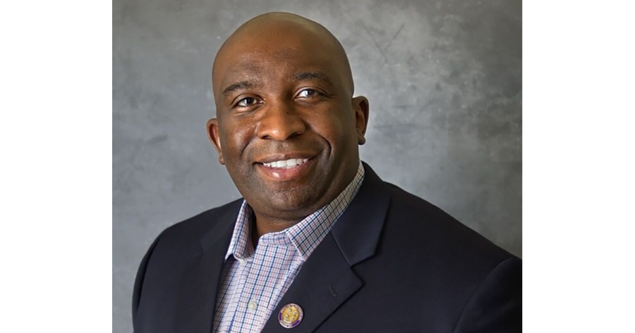 a person in a sportcoat and shirt poses for a portrait