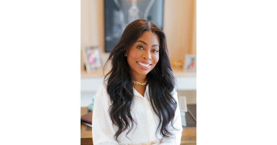 A woman sits for a portrait in front of a mantlepiece