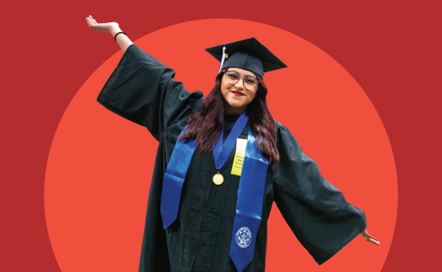 A person in cap and gown poses against a red backdrop with their hands spread wide