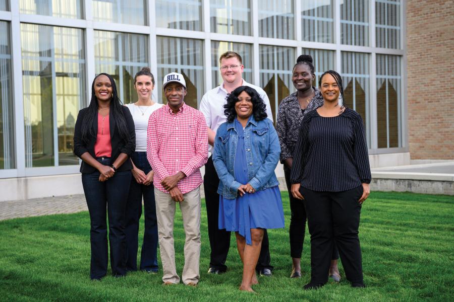A group of people pose for a group photo in front of New Mainup p