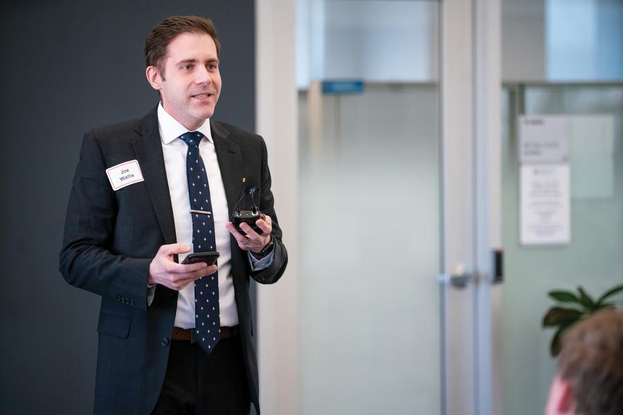 A person standing to speak to a room of people