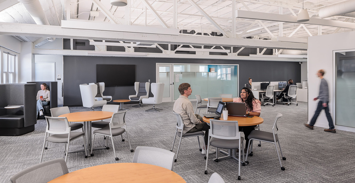 Open study and collaboration area inside the Management Education Center in Minneapolis, with tables, lounge seating and computer workstations.