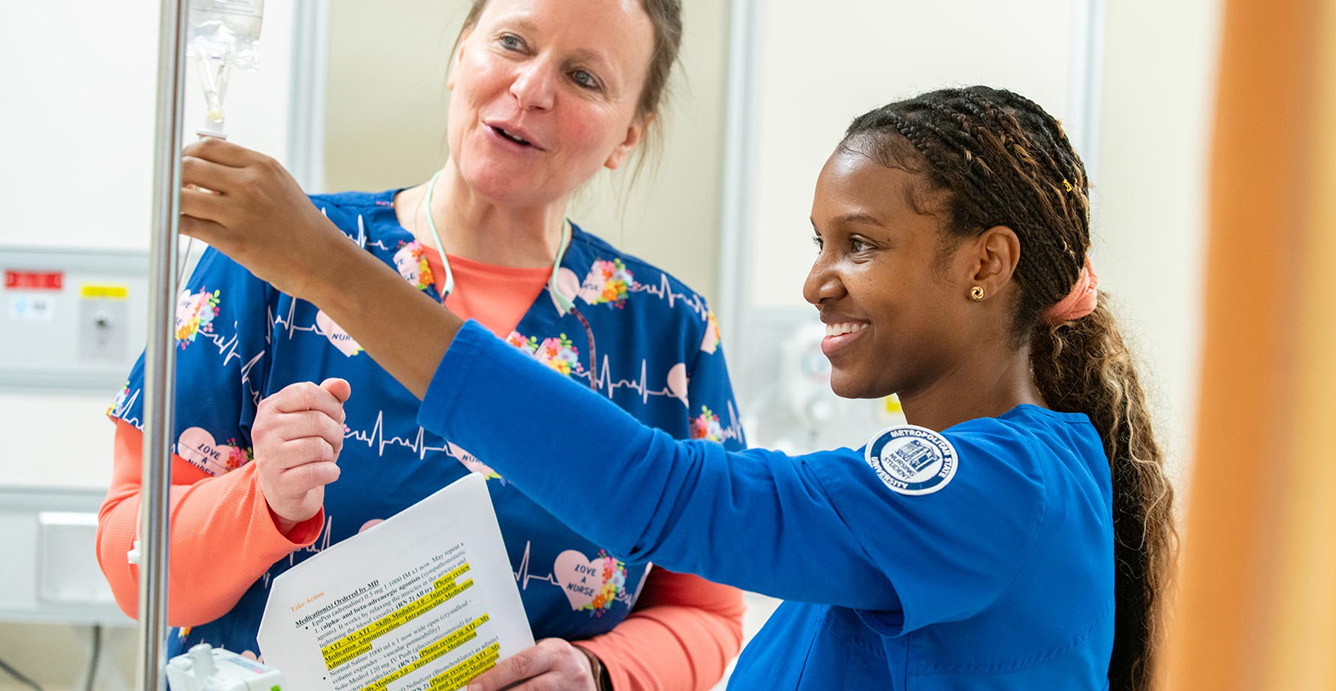 A nursing student and instructor practice setting up an IV in Metro State’s nursing simulation lab.